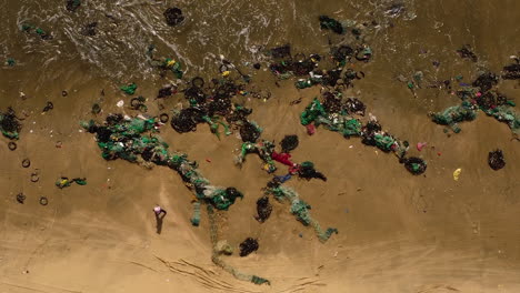 arriba hacia abajo de la red de pesca de plástico de la contaminación del océano en la playa de arena tropical del océano después de la tormenta del monzón, concepto de contaminación marina agrícola industrial