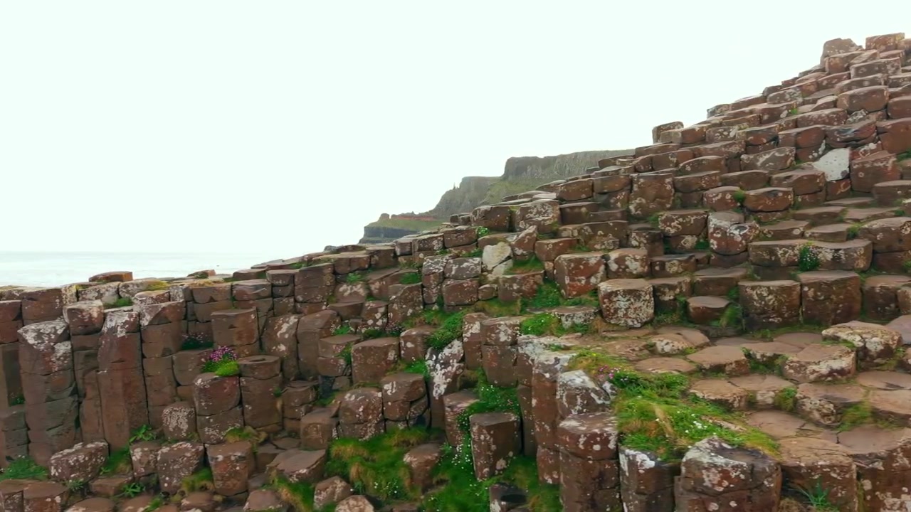 Video aereo 4K 60FPS che rivela le colonne di basalto al Selciato del Gigante a Bushmills, Contea di Antrim nell'Irlanda del Nord, Regno Unito. Prodotto in 3840x2160 e con colore Rec709.