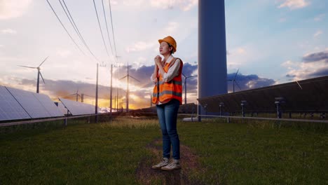 full body side view of asian female engineer with safety helmet pray for something with solar panel and wind turbines