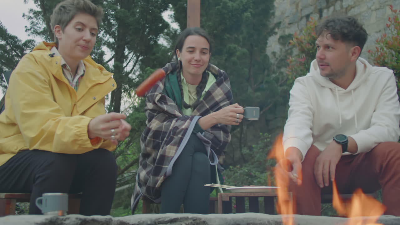 Friends Cooking Sausages, Having Tea and Talking by Campfire