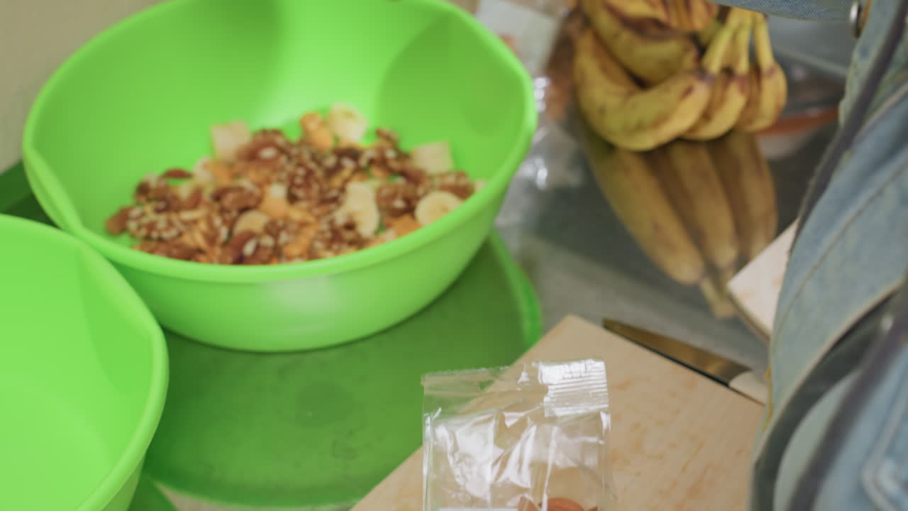 Preparazione di ingredienti nutrienti per un pasto, taglio e preparazione di ingredienti per una sana esperienza culinaria, preparazione di cibo con frutta fresca e mandorle per un pasto sano