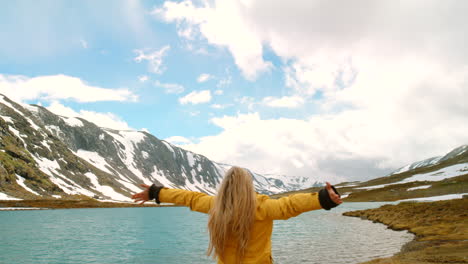 woman enjoying the scenery in the mountains by a lake.