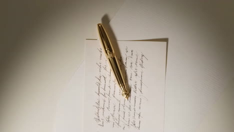 elegant gold pen on handwritten paper