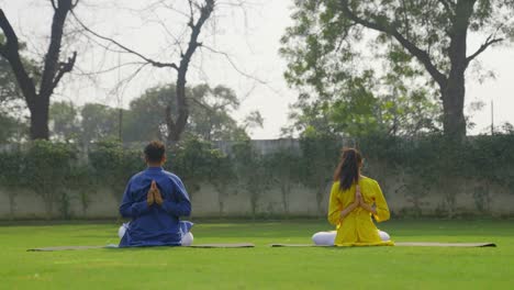 reverse namaste yoga being done by an indian couple