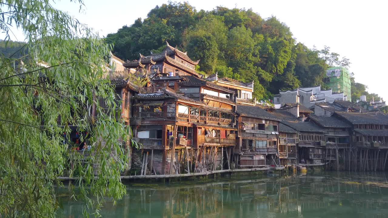 vista matutina de las antiguas casas históricas de madera diaojiao en las orillas del río tuo, que fluye a través del centro del casco antiguo de fenghuang