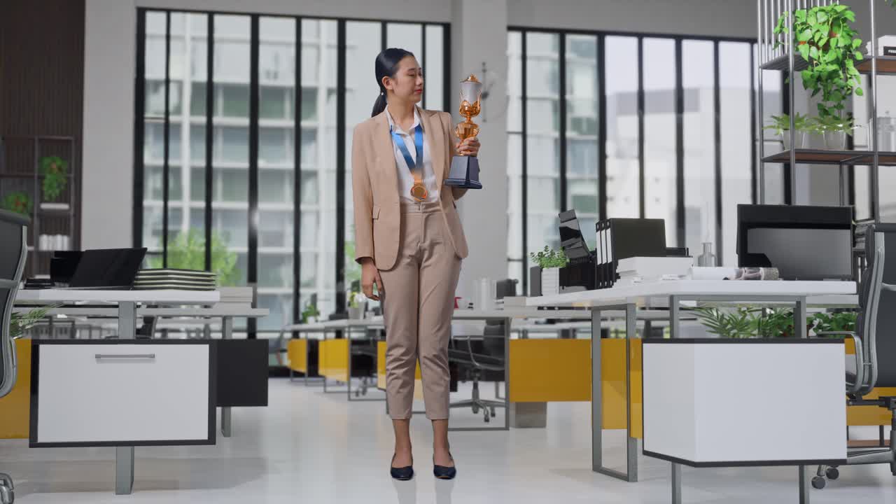 Full Body Of Upset Asian Business Woman In A Suit With A Gold Medal Looking At Trophy Then Shaking Her Head Being Unsatisfied Winning As The First Winner In The Office
