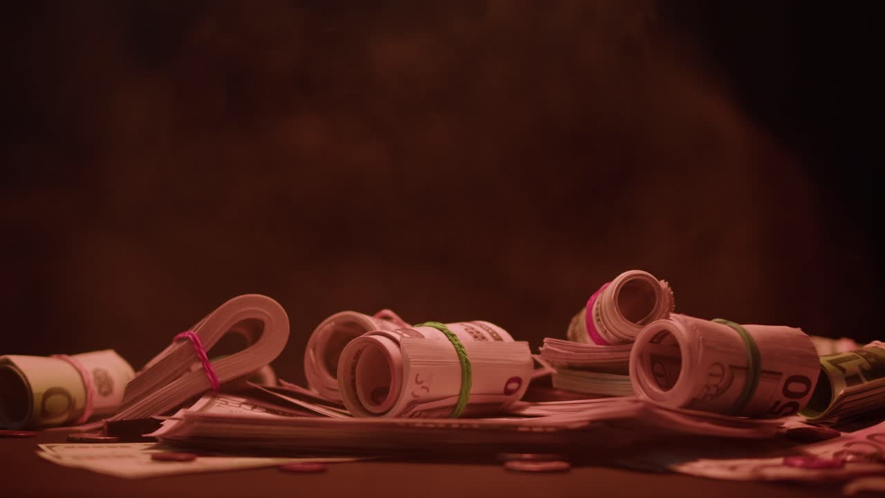 Bundles of Money and Banknotes on a Dark Table