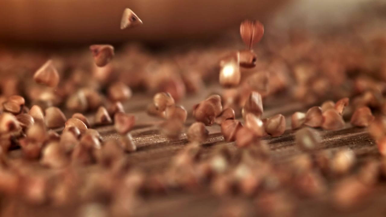 Buckwheat Grains Falling in Slow Motion on a Wooden Surface