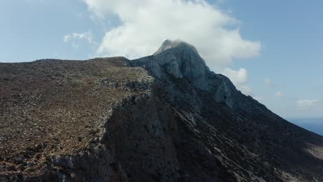 Aerial-drone-shot-of-mountainside-with-clouds-around-the-peak