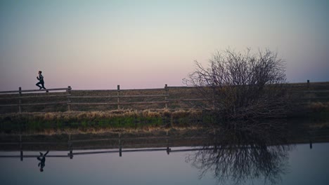 Boy-Running-Across-Road-by-a-Pond