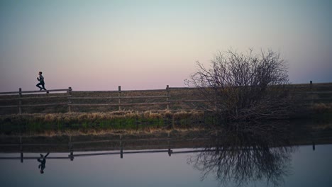 boy running across road by a pond