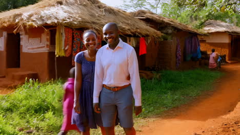 a happy couple and children walking through an african village