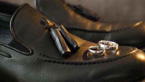 wedding rings on groom's black shoes