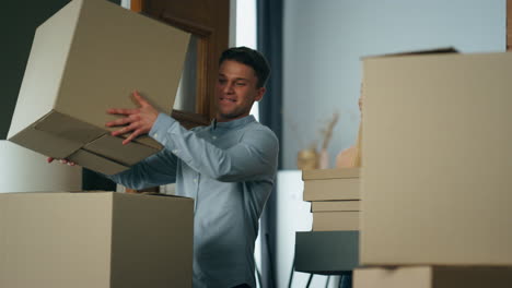 family carrying cardboard boxes to new apartment. couple excited by moving.