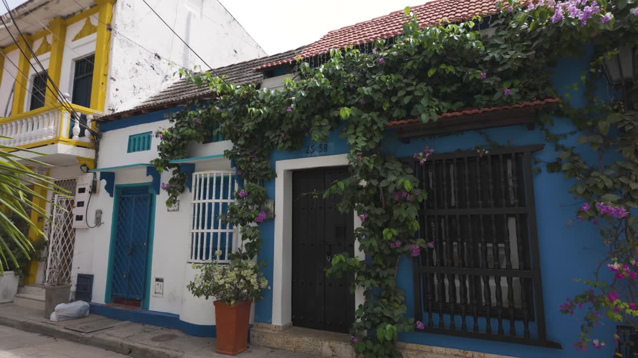Incantevole casa blu a Getsemani, Cartagena, con viti rigogliose e fiori che adornano la facciata