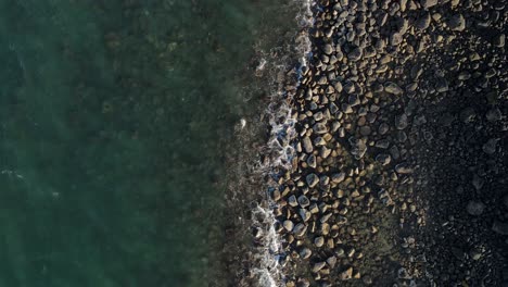 a high revealing drone video looking down at the raw rocky coastline of the small town of bargara located in the region of bundaberg queensland australia