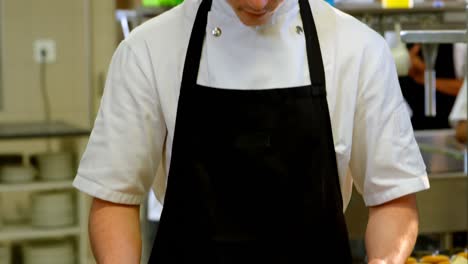 chef holding cookie tray in hand at kitchen 4k