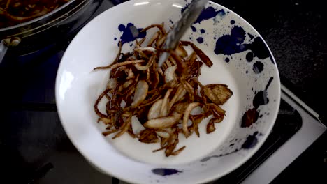 cebollas en rodajas doradas y crujientes que se colocan en un plato