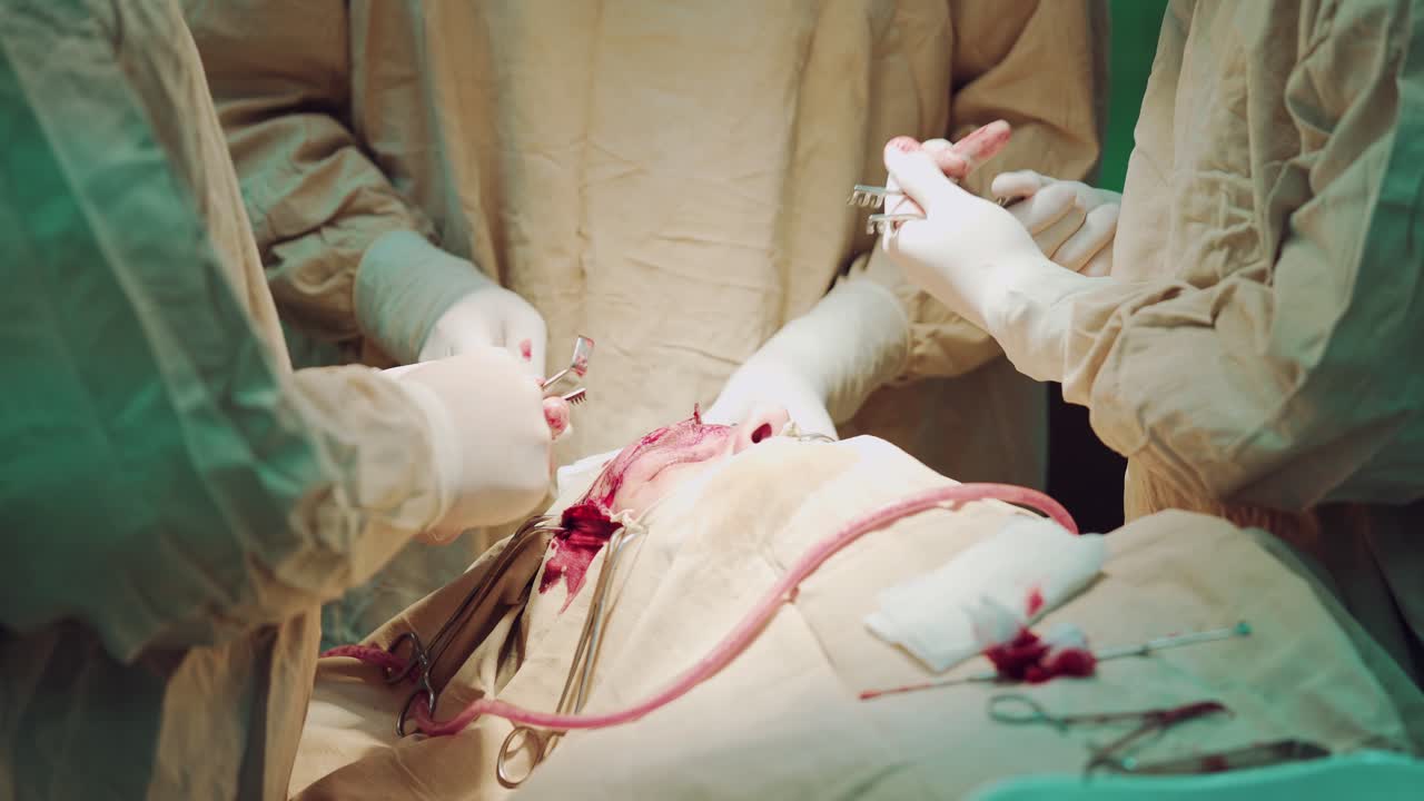 Doctor wearing protective clothing performing surgery using sterilised equipment