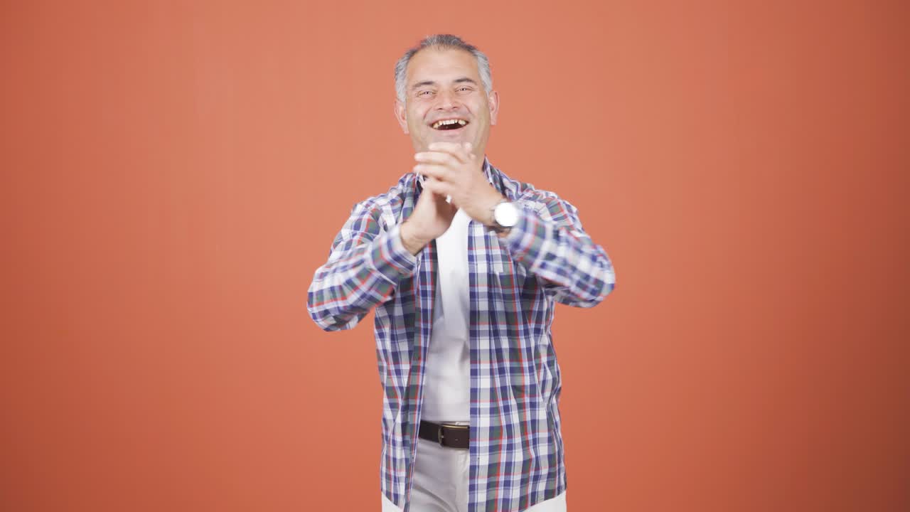 hombre aplaudiendo emocionado a la cámara.
