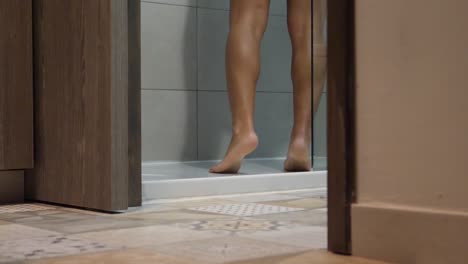 low angle view of woman's feet as she gets into the shower