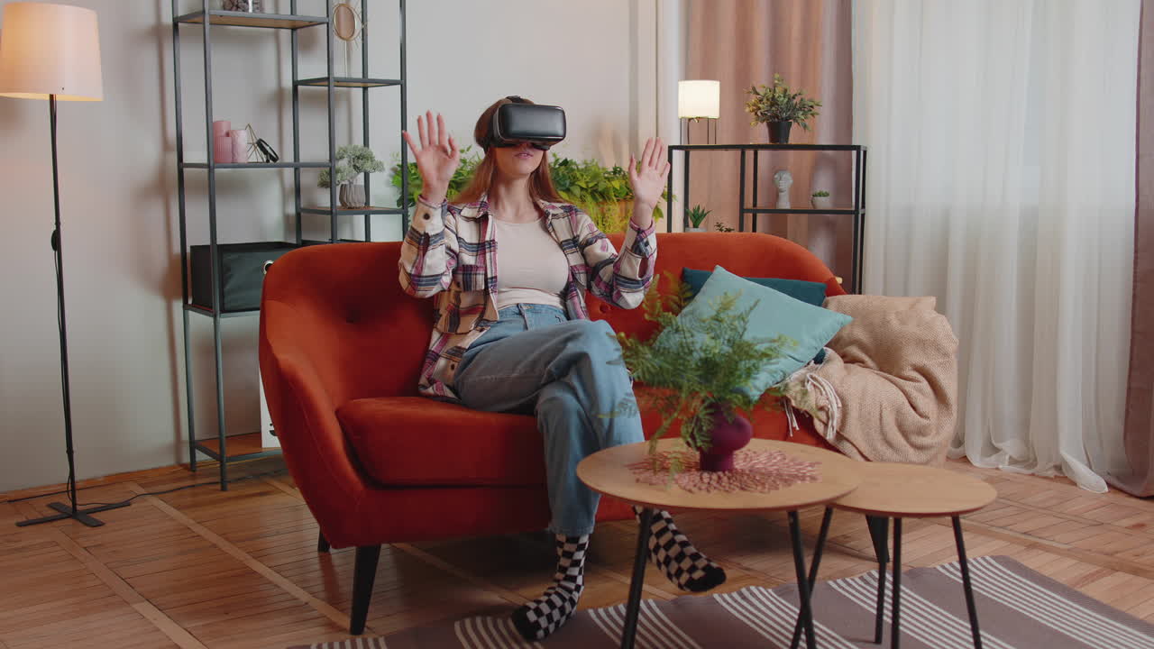 niña joven usa gafas de realidad virtual en casa juega videojuegos en 3d haciendo gestos con las manos