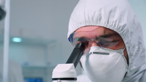 primer plano de un científico que lleva a cabo un análisis genético utilizando un microscopio