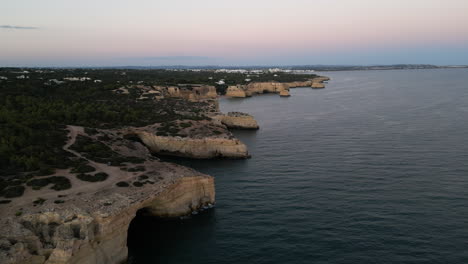 Drohnenvideo-Eines-Sonnenuntergangs-über-Höhlen-An-Der-Küste-Der-Algarve,-Portugal