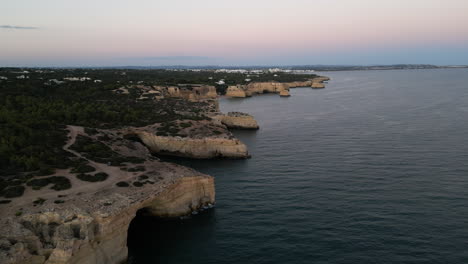 drone video of a sunset over caves on the coast of the algarve, portugal