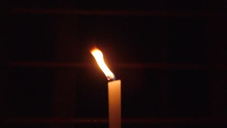 una vela encendida en la oscuridad