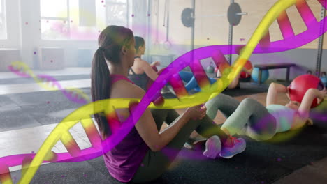 animación de cadenas de adn sobre diversas mujeres entrenamiento cruzado en parejas con bolas de medicina en el gimnasio