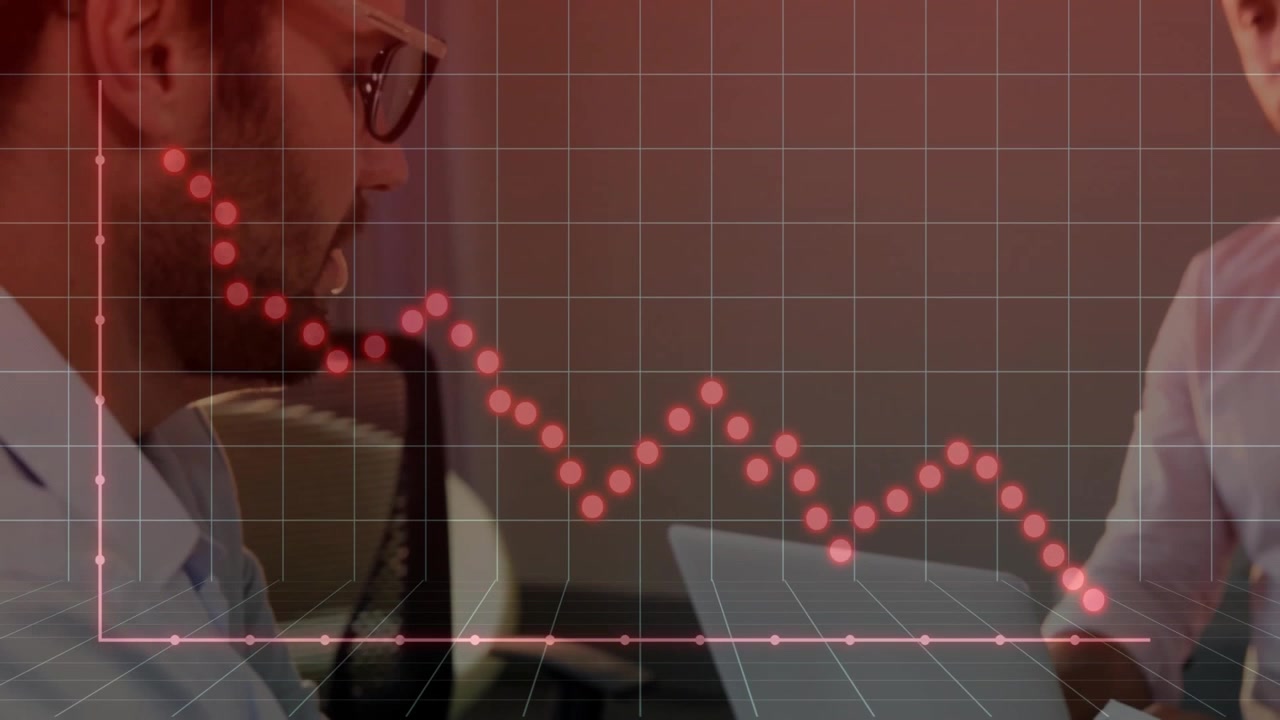 Two male colleagues analyzing finance data on laptop, displaying red dotted line graph overlay