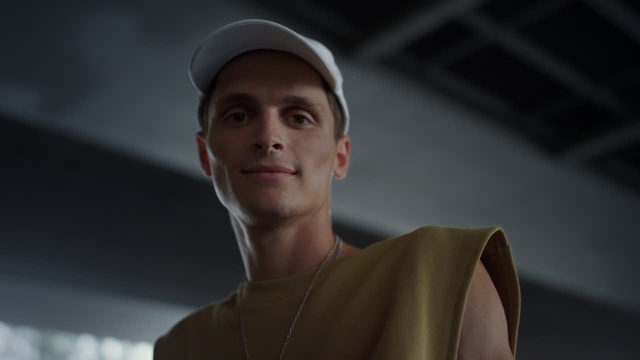 스케이트파크에서 카메라를 보는 웃는 남자. 야외에서 아름다운 남자 얼굴.