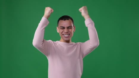 man celebrating victory over green background