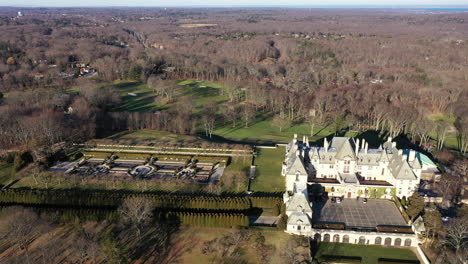 an aerial view over an upscale, luxury mansion with an eight reflection pool fountain, on long island, ny