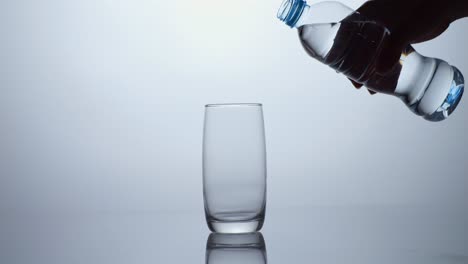 verter agua de la botella en el vaso