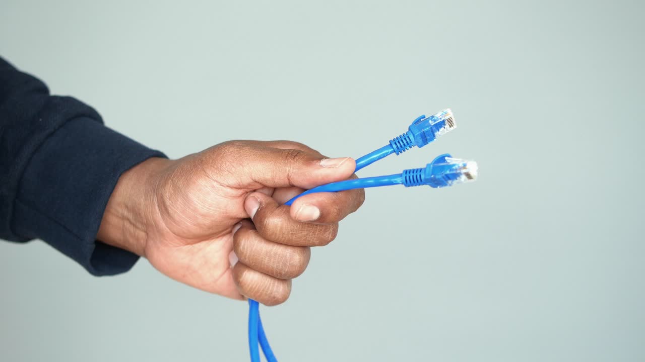 Hand holding two ethernet cables