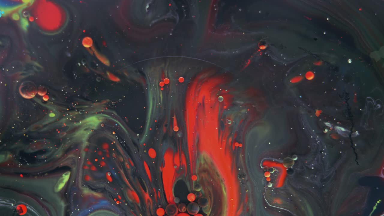 Burbujas de colores. Mezcla abstracta roja, amarilla y verde sobre fondo negro. Fondo artístico de pintura de color.