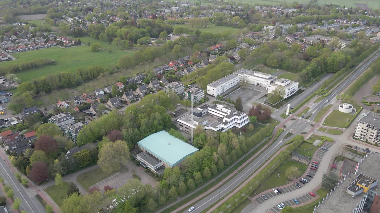 descripción aérea de un largo camino que atraviesa una pequeña ciudad suburbana
