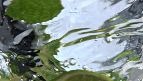 fizzy mint cocktail rotating inside clean glass closeup. vitamin water spinning