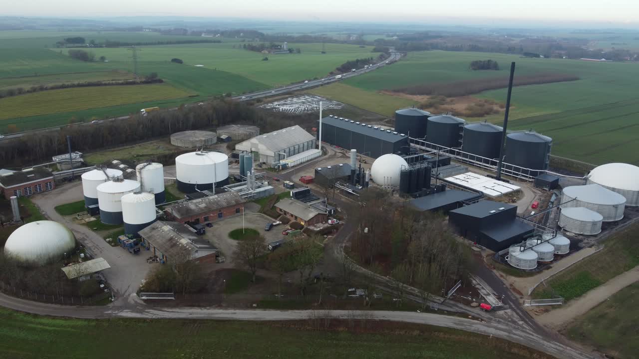 Aerial view of biogas facility structures in rural Denmark, highlighting renewable energy technology, storage tanks, and agricultural integration