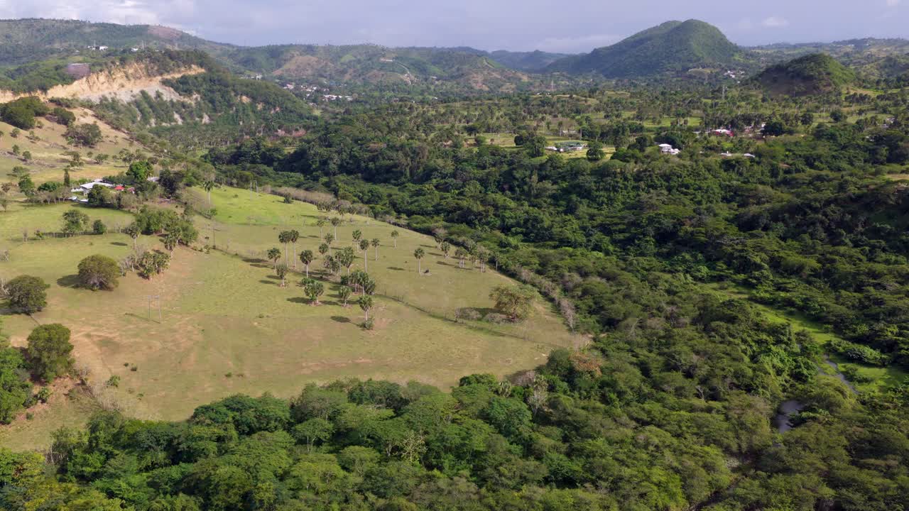 Drone perspective of green hills and countryside in Santiago, Dominican Republic. Aerial forward