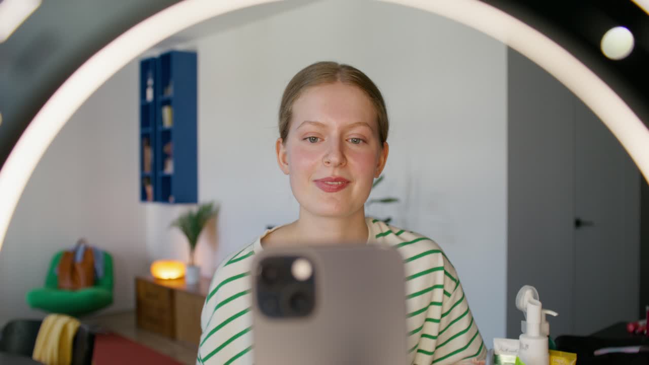 una mujer joven haciendo una llamada de video delante de un espejo.