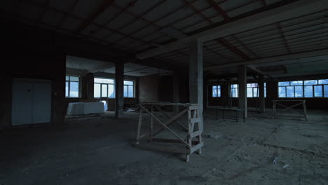 spacious premise in the unfinished building or old forlorn warehouse. large room with bare walls, columns and scaffolding.