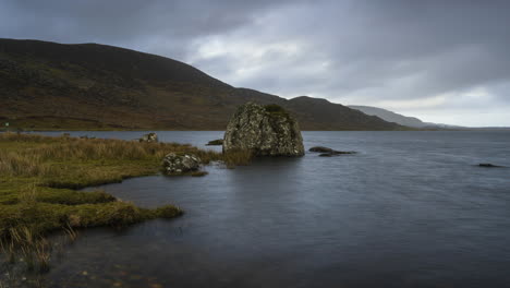 time lapse on a remote lake shore on dramatic cloudy day in ireland