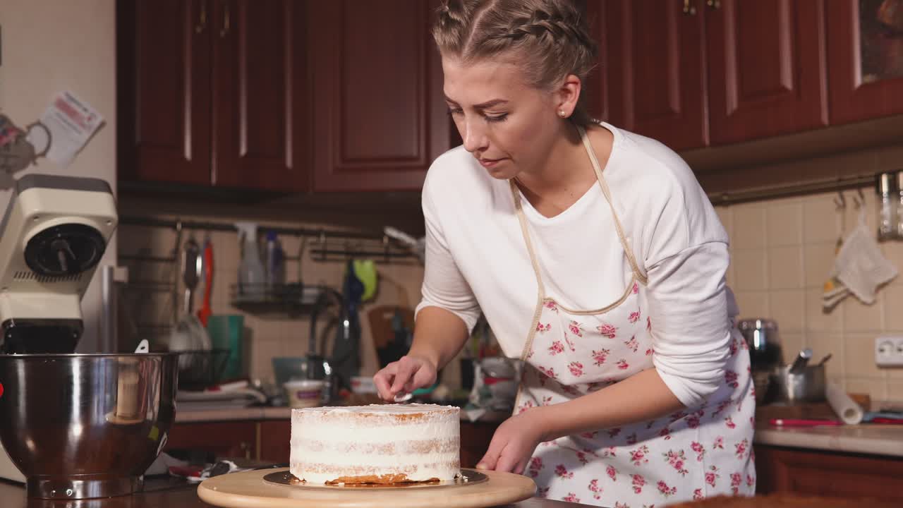 Donna che decora una torta in cucina