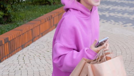 joven con bolsas de papel en la calle