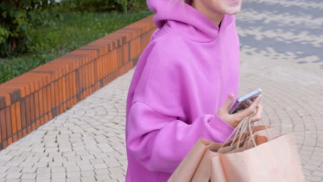 joven con bolsas de papel en la calle