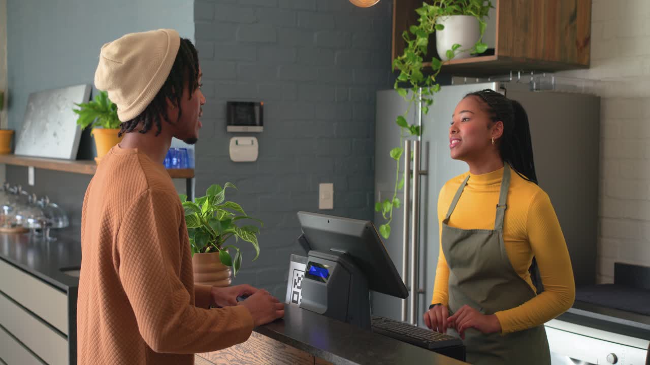 Entrando em um café: clientes diversos e barista se cumprimentando no balcão enquanto realizam o pagamento pelo smartphone