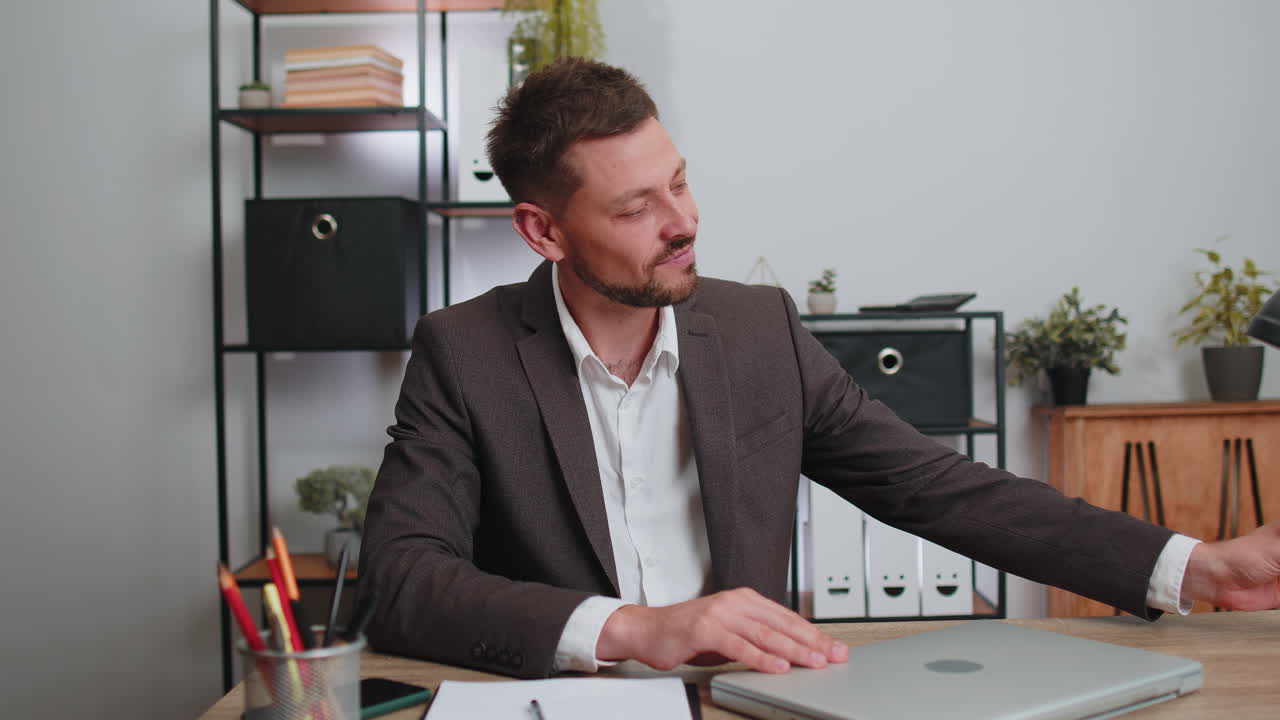 Uomo d'affari che beve champagne per celebrare un accordo contrattuale di successo dopo aver lavorato al portatile in ufficio.